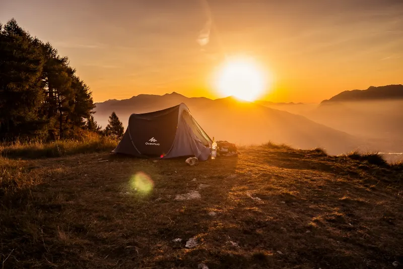 A tent at sunrise on a mountain ridge